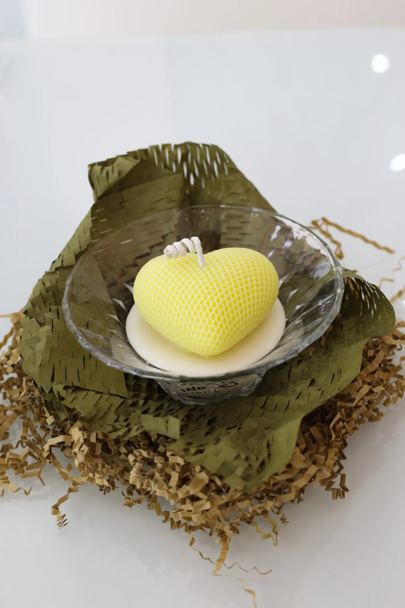 Textured golden heart candle in glass bowl